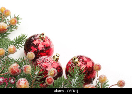 Tannenzweigen, Beeren und Kugeln mit Schnee für Weihnachten Grenze. Stockfoto