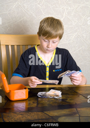 Ein 12 Jahre alter Junge zählt, britische £10 und £20 Banknoten Stockfoto