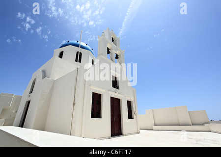 Eine blaue Kuppel orthodoxe Kirche vor einem strahlend blauen Himmel. Das Dorf Oia, Santorin, Griechenland. Niedrigen Winkel Ansicht. Stockfoto