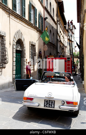 Braut sitzt im Auto und gonna Trauung gestrandet Feuerwehr LKW in Cortona, Toskana, Italien Stockfoto