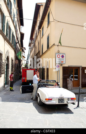 Braut sitzt im Auto und gonna Trauung gestrandet Feuerwehr LKW in Cortona, Toskana, Italien Stockfoto