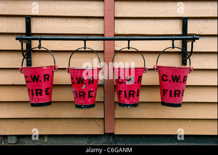 Vier alte Feuer Eimer hängen am Bahnhof Bewdley, Worcestershire, England (Severn Valley Railway) Stockfoto