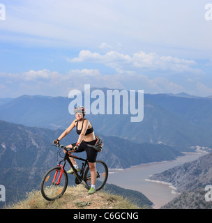 Junge Frau posiert sitzend auf einem Mountainbike Stockfoto