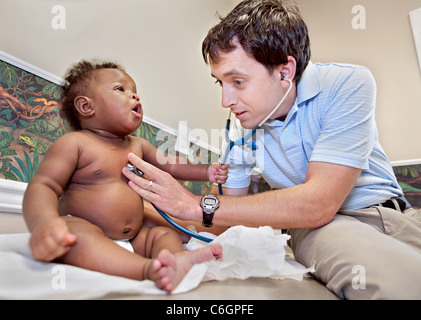 Ein pädiatrische Arzt untersucht ein Kind während einer Untersuchung. Stockfoto