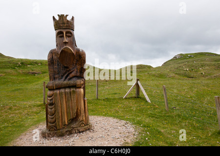 Geschnitzte hölzerne Darstellung eines Königs von Lewis-Schachspiel in der Nähe der Dünen, wo es gefunden wurde, Traigh Uige auf den Hebriden. Stockfoto