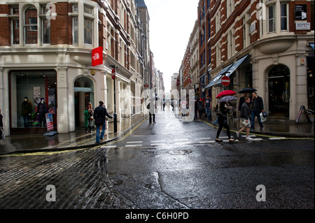 Eine Sommer-Regen-Dusche fällt auf Shopper in Covent Garden in London. Stockfoto