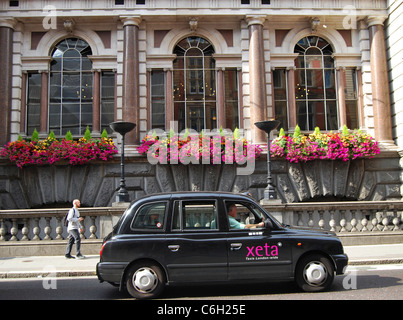 Traditionelle Londoner schwarzen Taxi Fleet Street im Sommer die Fullers Ale & Pie House Pub mit seinen bunten Blumenkästen weitergeben. Stockfoto