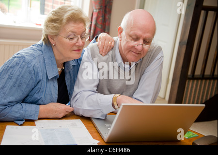 Älteres paar getrost bezahlen ihrer Rechnungen zusammen online Stockfoto