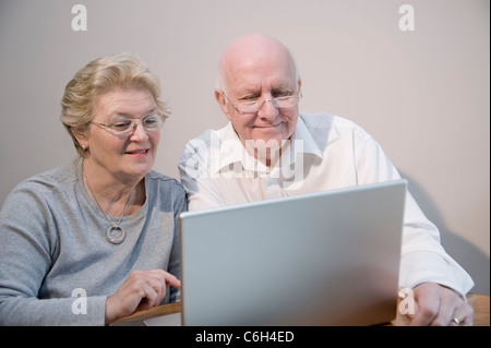 Älteres paar Lächeln und genießen Sie mit einem Laptopcomputer Stockfoto