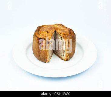 Melton Mowbray Pork Pie auf einem weißen Teller ausgeschnitten auf weißem Hintergrund Stockfoto