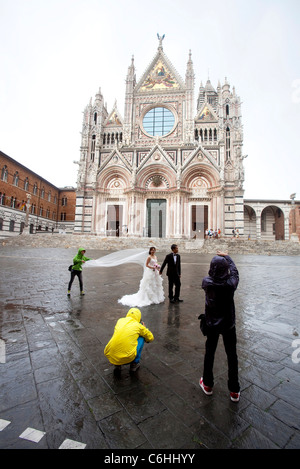 Trauung und Fotograf: Braut und Bräutigam nach der Hochzeit vor der Kathedrale, Siena, Toskana, Italien Stockfoto