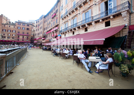 Touristen sitzen an Bar und Restaurant in Piazza del Campo entfernt, Siena, Toskana, Italien Stockfoto