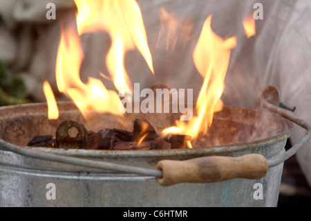 Nahaufnahme von Flammen, die aus einen kleinen Grill als die Kohle heizt Stockfoto