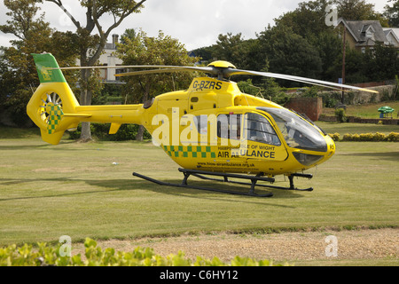 Hampshire & Isle Of Wight Eurocopter EC-135 Luftrettung G-BZRS nach einer operativen Landung auf einer Wiese. Stockfoto