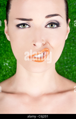 Closeup Mode Porträt einer Frau, die ein seltsames Gesicht isoliert auf grün ziehen Stockfoto