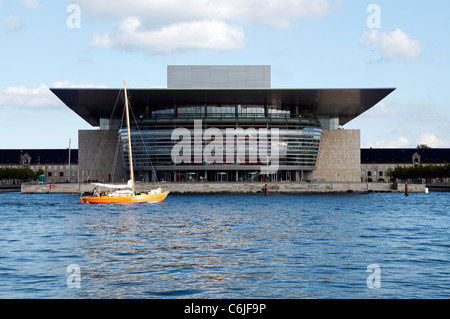 Segelboot vorbei am Königlich Dänischen Opernhaus im Kopenhagener Binnenhafen, Dänemark. Moderne Architektur von Henning Larsen. Gespendet von A.P. Møller. Stockfoto