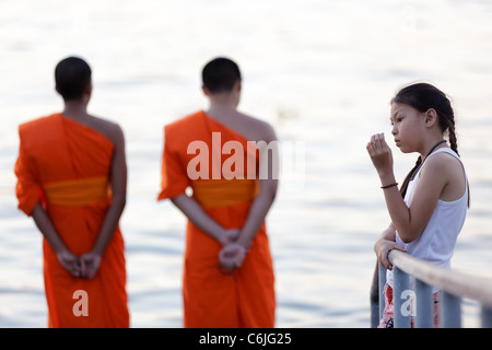 zwei Mönche stehen vor Fluss Chao Phraya und kleine Mädchen denken, Bangkok, thailand Stockfoto