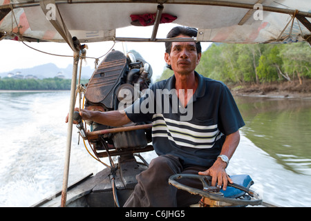 asiatischer Mann fahren lange tailed Boot in Krabi Fluss, thailand Stockfoto