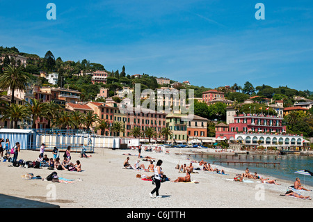 Schwimmer und Sonnenanbeter genießen Sie die Sonne am Strand vor dem eleganten Gebäuden von Santa Margherita Ligure Stockfoto