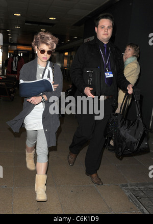 Kelly Osbourne scheint eine böse Verletzungen erlitten haben, nachdem sie am Londoner Flughafen Heathrow mit dem rechten Arm in gerissen wurde Stockfoto