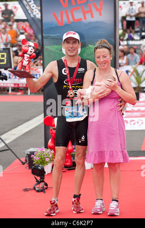 Die Vichy volle Distanz Triathlon. Hier der Triathlet Gewinner Stephen BAYLISS in Begleitung seiner Frau und Neugeborenen Baby. Stockfoto