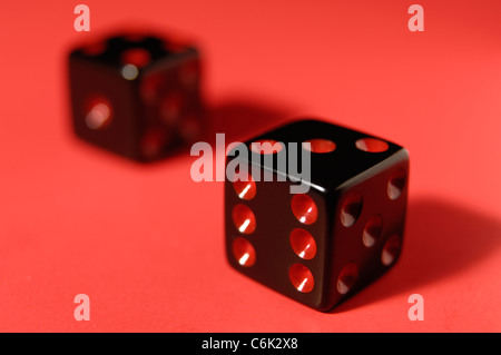 Zwei schwarze Würfel auf rotem Hintergrund isoliert Stockfoto
