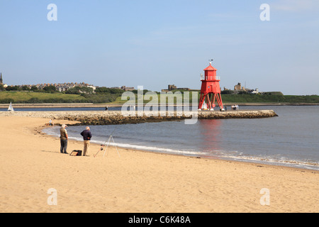 Zwei Männer Angeln vom Herde Sand oder Littlehaven Strand, Buhne Leuchtturm im Hintergrund bei South Shields, North East England, UK Stockfoto