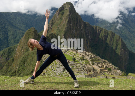 Junges Mädchen tun Dreieck mit Die verlorene Stadt der Inkas im Hintergrund darstellen, Machu Picchu, Cusco Region, Peru Stockfoto