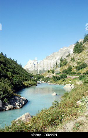 Ein Fluss fließt durch eine steile Tal in den Alpen in der Nähe von Mont Blanc mit den Bergen des Col Ferret im Hintergrund Stockfoto