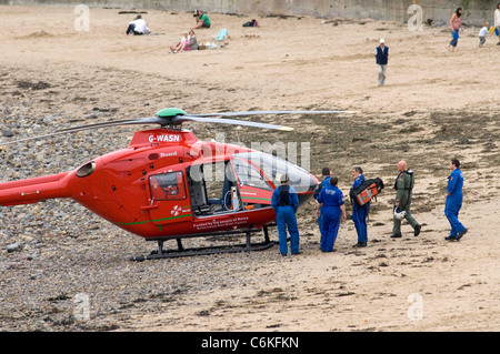 Swansea Küstenwache mit Wales Air Ambulance Helikopter Crew bei Langland Bucht in der Nähe von Swansea heute Nachmittag Stockfoto