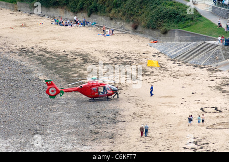 Der Wales Air Ambulance Helikopter landet in der Mitte Langland Bucht in der Nähe von Swansea nach dem Besuch eines Vorfalls Stockfoto