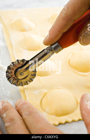 Schneiden frische Ricotta-Ravioli mit Gebäck-Rad Stockfoto