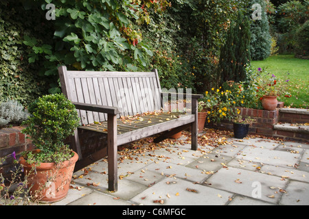 Garten-Bank auf eine traditionelle Steinplatten Terrasse im Herbst / Herbst Stockfoto