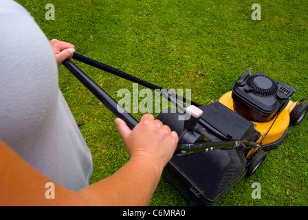 Frau, Rasenmähen, Schwerpunkt Mäher Stockfoto