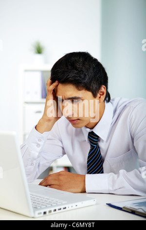 Porträt eines Geschäftsmannes Blick auf Laptop-Bildschirm im Büro Stockfoto