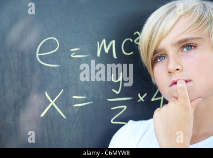 Schüler stehen in der Nähe von Blackboard mit Formel Stockfoto