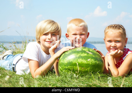 Kinder liegen im Rasen mit rote Wassermelone Stockfoto