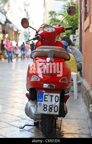 Leuchtend roten Lippenstift Shinny Lambretta Scooter geparkt an einem heißen Sommerabend auf eine historische Gasse in der Altstadt von Corfu Stockfoto