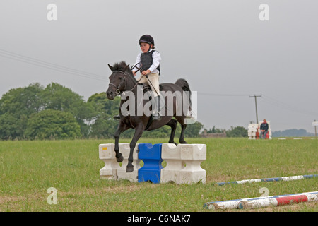 Junges Mädchen Reiter in der Luft über Sprung North Cotswold Pony Club Camp 2011 Stockfoto