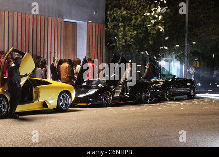 Dollar-Noten sind in der Luft neben luxuriösen Autos vor einem Nachtclub, am Set des neuen Flo Rida Videos in Hollywood geworfen. Stockfoto