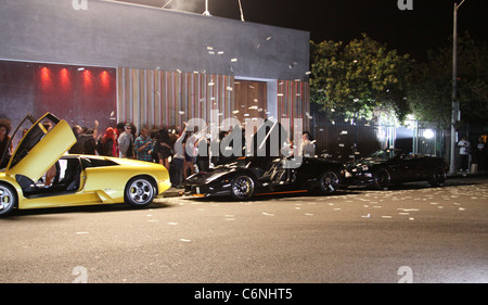 Dollar-Noten sind in der Luft neben luxuriösen Autos vor einem Nachtclub, am Set des neuen Flo Rida Videos in Hollywood geworfen. Stockfoto