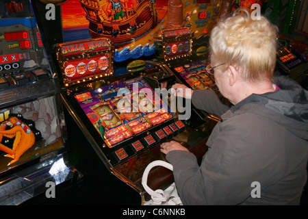 Frau spielen Spielautomat. Stockfoto