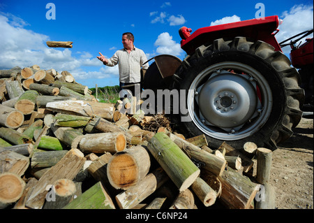 Ein junger Landwirt im Bild mit seinem roten Massey Ferguson Traktor, Dorset, Großbritannien Stockfoto