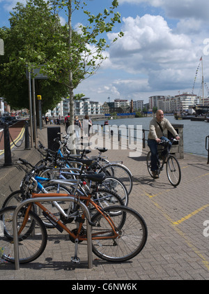 dh City Radweg BRISTOL DOCKS BRISTOL Fahrradständer Parken Radfahrer Fahrrad Radfahren uk Mann Reiten Pflaster Uferstraße Stockfoto