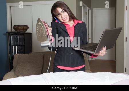Glücklich und zuversichtlich Geschäftsfrau leicht Hausarbeit, ein Anruf und die Arbeit auf dem Laptopcomputer verwalten. Stockfoto