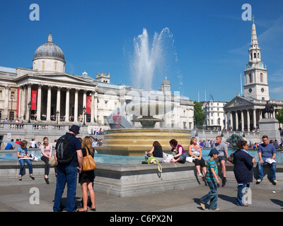 Touristen in Trafalgar Square in London mit der National Gallery und St. Martin-in-the-Fields im Hintergrund Stockfoto