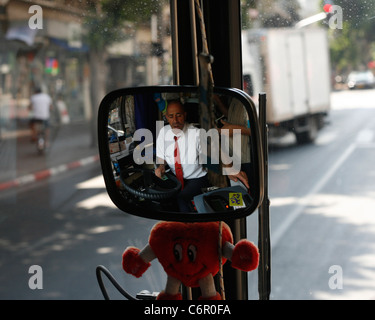 Ein israelischer Busfahrer in Tel Aviv ist ein Fahrgast seine Fahrkarte geben. Stockfoto