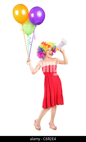 In voller Länge Portrait von eine Frau schreien über einen Lautsprecher und Ballons halten Stockfoto