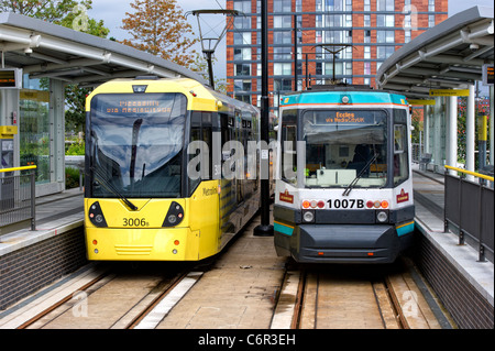 Paar von Straßenbahnen auf dem Manchester Metrolink-System warten nebeneinander in einer station Stockfoto