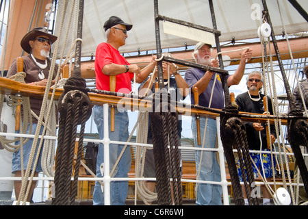 Ein erfahrener Seemann führt Knoten binden an der Schiene der Extraklasse das Segelschiff Star of India im San Diego Maritime Museum Stockfoto